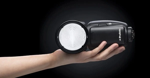 Накамерний спалах Profoto A10 AirTTL на відкритій долоні з круглою лінзою Френеля, діодним пілотом та металевим башмаком кріплення